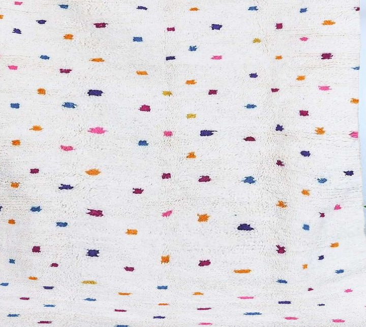 Close-up of the 'Noura' Azilal rug, highlighting the colorful dots, the texture of the wool and the unique design